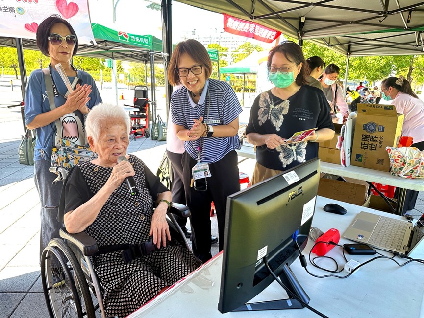 95歲的翁奶奶（左前）在卡拉OK攤位開心高歌，氣氛溫馨歡樂。(圖/北台灣無障礙運輸產業工會 提供)