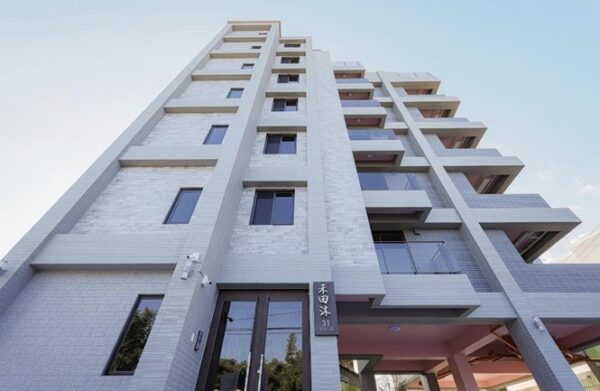 建築立面以樸實簡約語彙呈現，搭配三面採光設計與低公設比規劃，使住宅回歸居住本質，打造專屬於住戶的私密領域與高品質生活空間。圖/業者提供