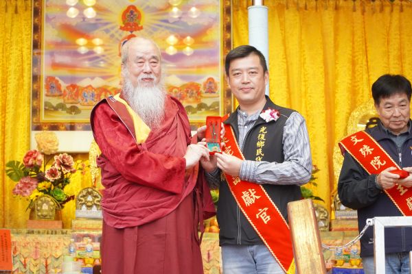 《圖說》世界佛教正心會於元旦到花蓮光復舉辦百日超薦法會，該會指導金剛上師恆性嘉措仁波且(左)致贈文殊菩薩墜子給光復鄉鄉民代表會主席廖翊鈞(右)。〈正心會提供〉