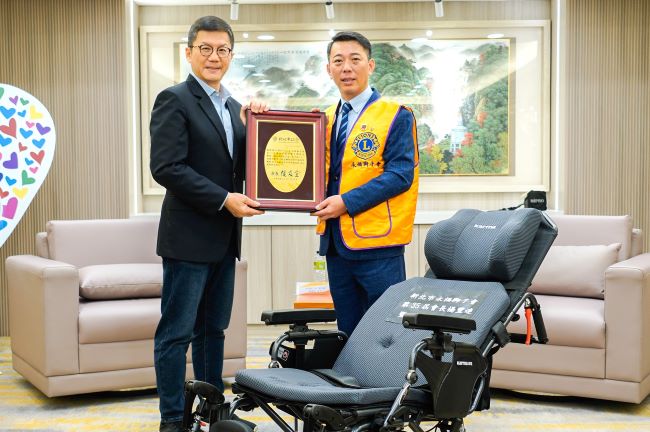 《圖說》副秘書長張其強代表侯友宜市長回贈感謝牌給第35屆永福獅子會會長楊豐連。〈社會局提供〉