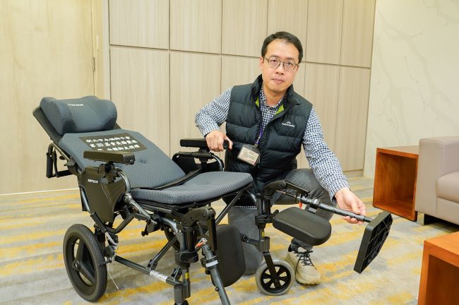《圖說》新北市輔具資源中心物理治療師徐麒晏表示，獲贈的高背輪椅可無段式仰躺，還有撥腳腳靠，更可拆卸扶手直接移位，方便特殊身障者。〈社會局提供〉